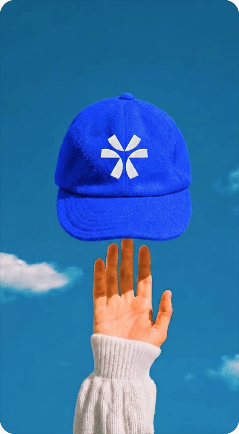Founder holding a blue Oripio cap against a clear sky